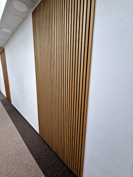 latte de bois dans un couloir pour correction acoutique dans un bureau de Pessac