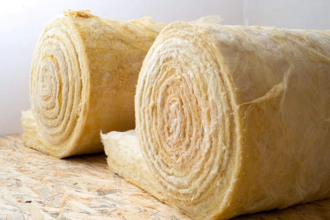 Artisan RGE Qualibat posant un isolant thermique dans une cloison lors d’un chantier à La Teste-de-Buch