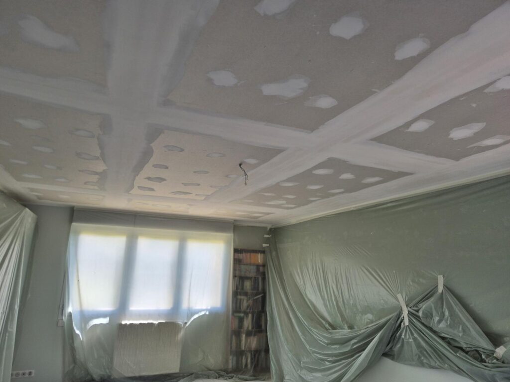 Faux plafond suspendu à dalles en cours de pose dans une pièce en rénovation