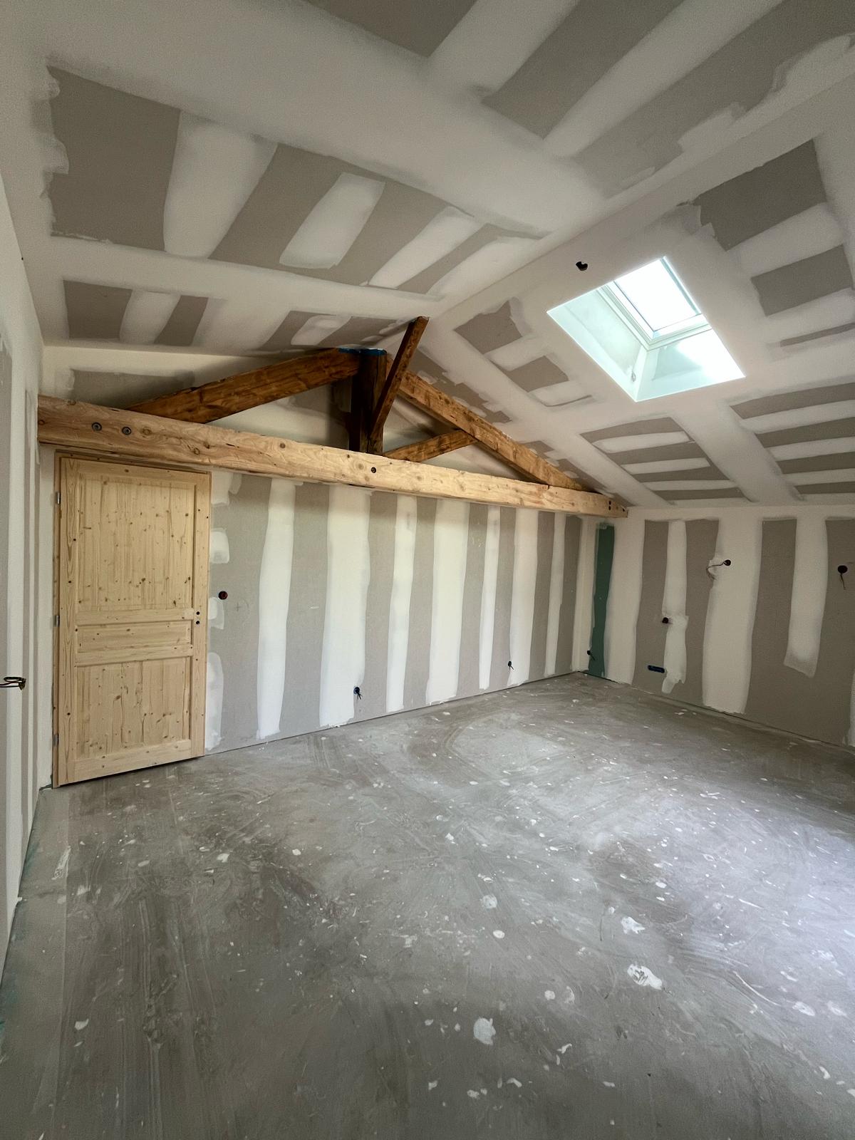 Combles aménagés sous rampants avec fenêtre de toit, plaques de plâtre posées et jointées