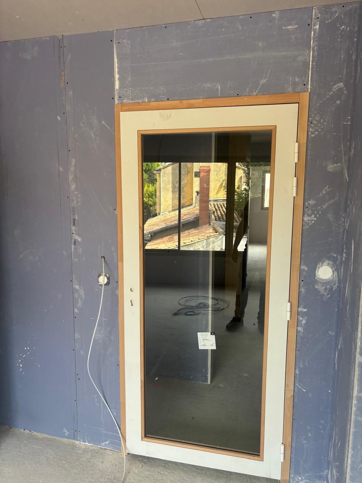 Porte vitrée phonique à châssis bois intégrée dans les plaques bleues haute densité — local acoustique Bordeaux