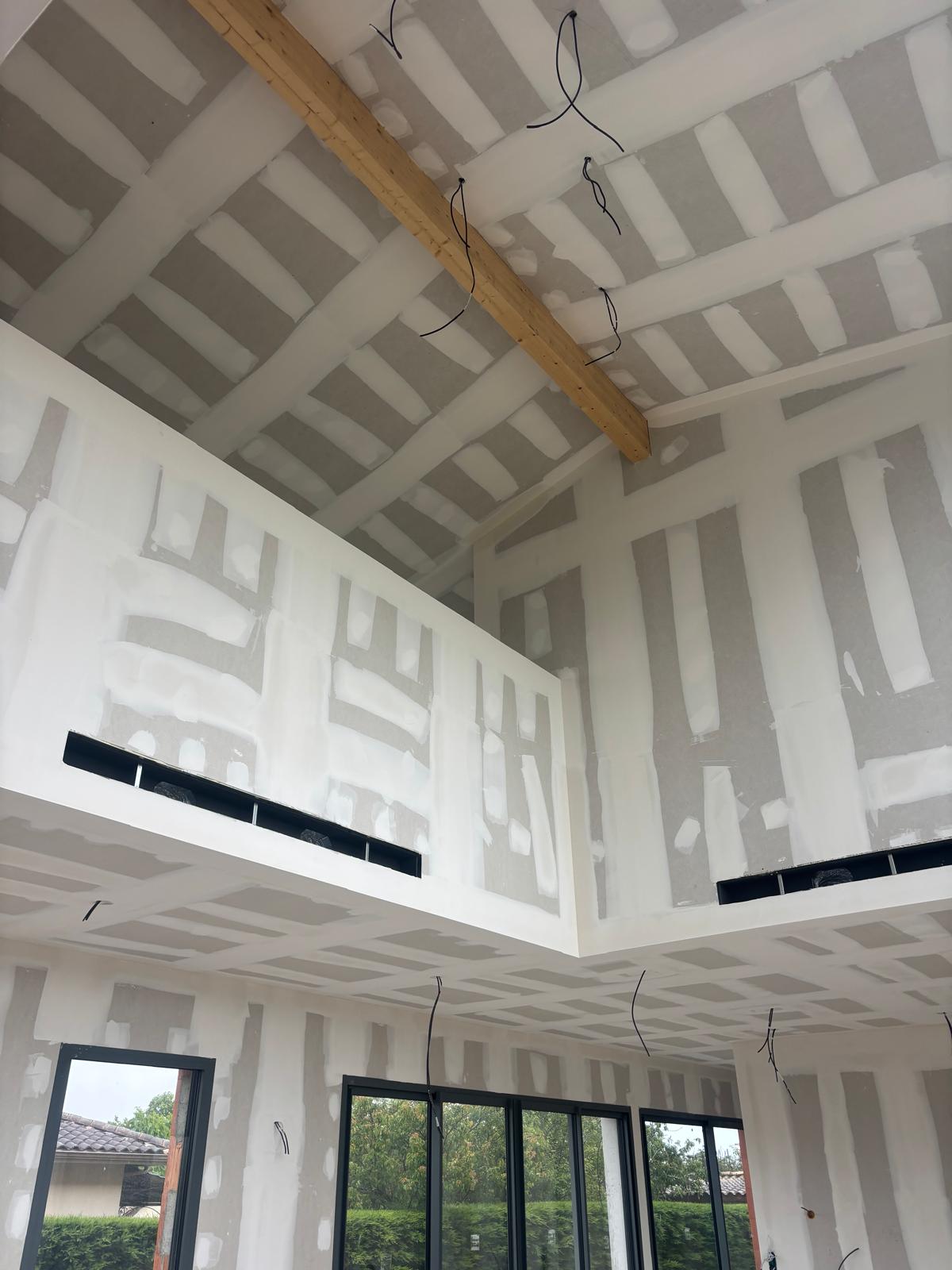 Vue du double hauteur en cours de pose des cloisons placo phoniques — maison neuve à Mérignac