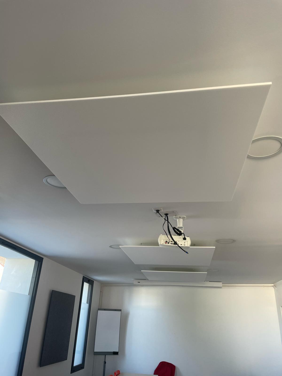 Gros plan sur les panneaux acoustiques suspendus avec projecteur intégré — salle de formation Gujan-Mestras