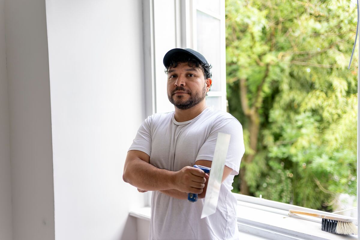 Artisan plâtrier tenant une truelle sur un chantier de rénovation intérieure